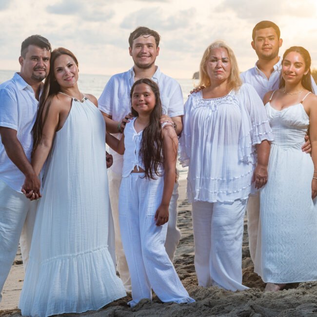 Extended family smiling together on the beach at sunset in Punta de Mita